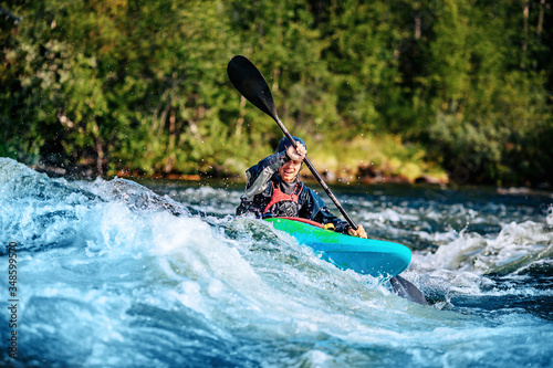 Extreme sport rafting whitewater kayaking. Guy in kayak sails mountain river