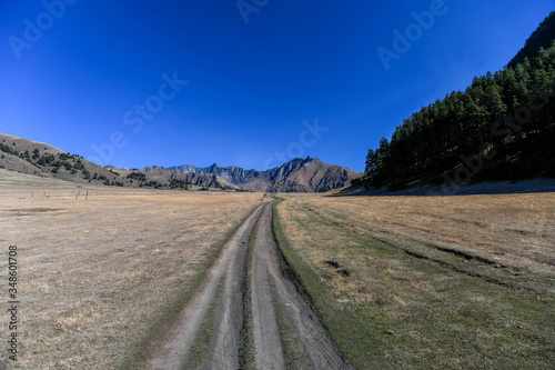 A trail at the entrance of Diklo in the Tusheti region with mountains in the background.