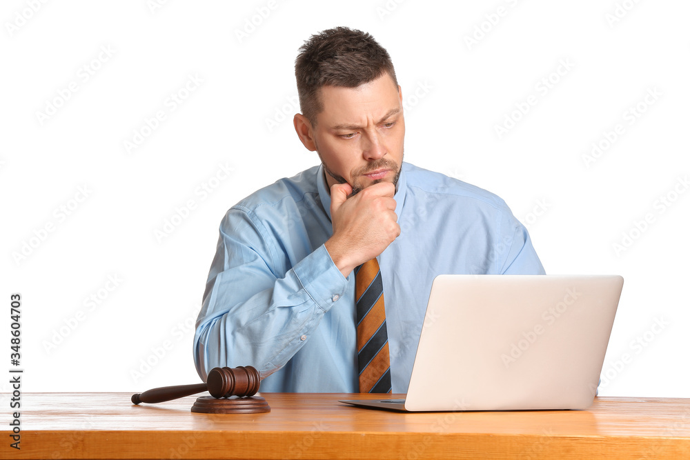 Male judge with laptop at table on white background Male judge with laptop at table on white background