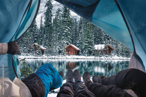 Group of traveler opening tent with wooden lodge in snow forest on Lake O'hara at Yoho national park