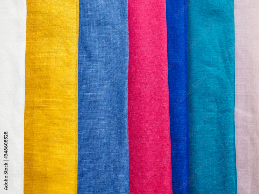 Fototapeta premium Multicolored cotton samples in vertical position. Woven texture and background.