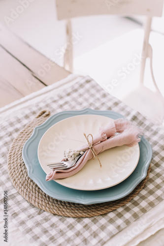 Elegant table setting. Table set for fine dining with metal fork and linen napkins on a plate. Home decor rustic table setting