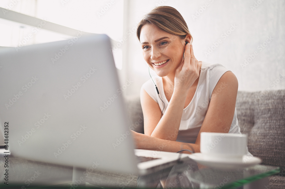 Attractive happy young student studying online at home, using laptop computer, headphones, having video chat, waving. Remote work, distance education. Video conference or virtual event on quarantine Attractive happy young student studying online at home, using laptop computer, headphones, having video chat, waving. Remote work, distance education. Video conference or virtual event on quarantine