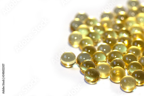 Yellow fish oil in capsules on a white background. Omega3 vitamins close-up. Capsules fish oil macro. Vitamins for health.