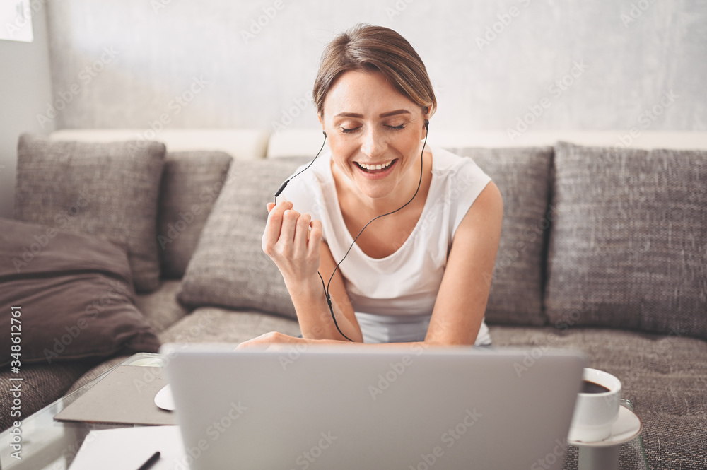 Attractive happy young student studying online at home, using laptop computer, headphones, having video chat, waving. Remote work, distance education. Video conference or virtual event on quarantine Attractive happy young student studying online at home, using laptop computer, headphones, having video chat, waving. Remote work, distance education. Video conference or virtual event on quarantine