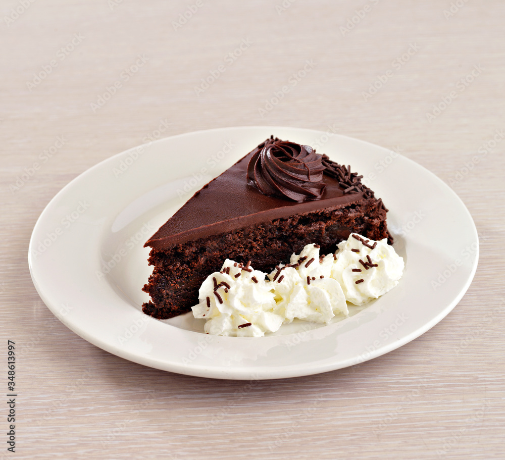 Chocolate cake with cream on white plate Chocolate cake with cream on white plate