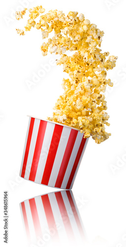 Flying popcorn from paper striped bucket isolated on white background