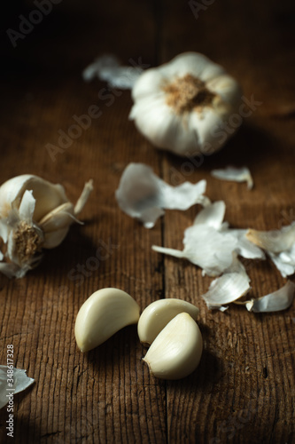 whole garlic head and cloves of garlic on wooden table
