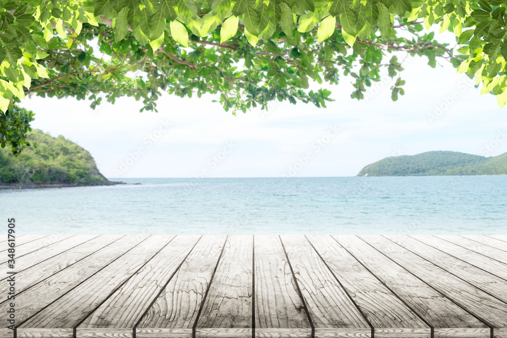 Fototapeta premium old wood table top on blurred beach background with coconut leaf. Concept Summer, Beach, Sea, Relax.
