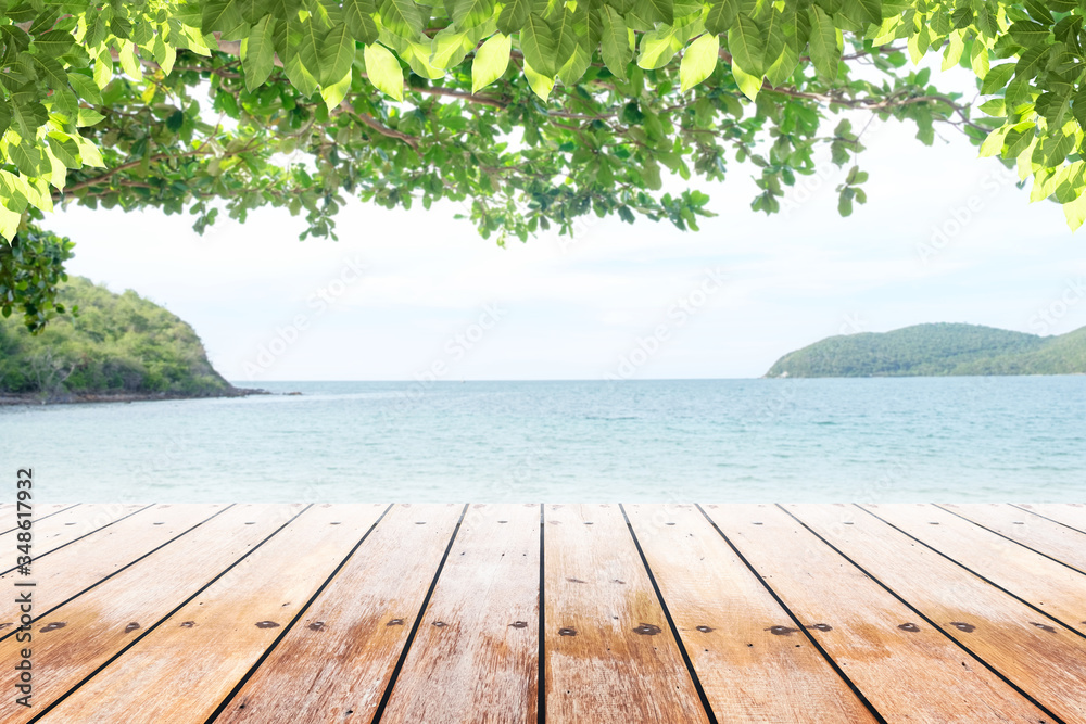 Fototapeta premium old wood table top on blurred beach background with coconut leaf. Concept Summer, Beach, Sea, Relax.