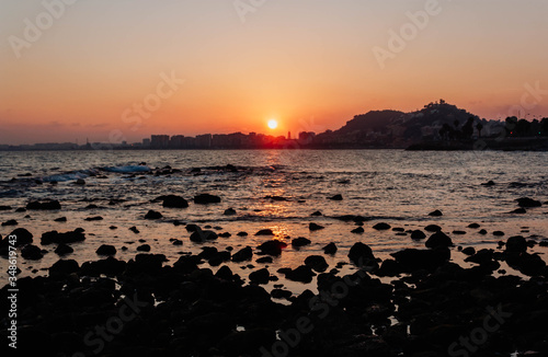 A sunset on a beach with rocks selective focus