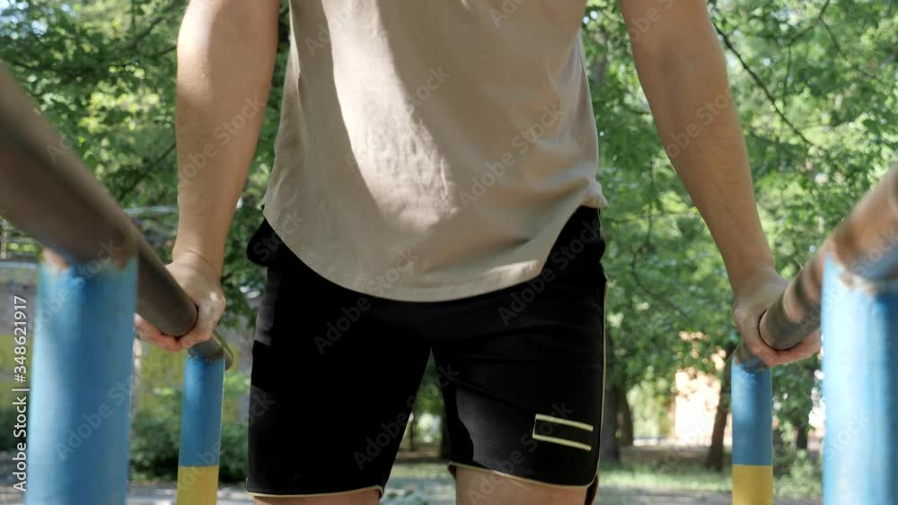 calisthenics street workout an athlete doing chest exersice on bars outdoors
