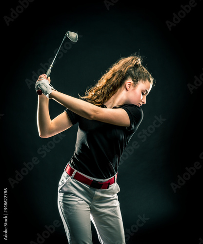 Girl looking for the perfect golf shot isolated on black background	