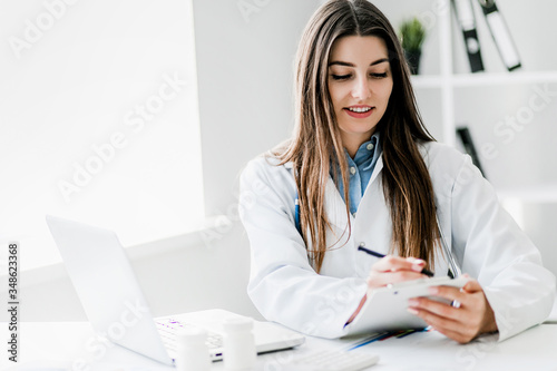 Female doctor working at office desk, healthcare professionals.