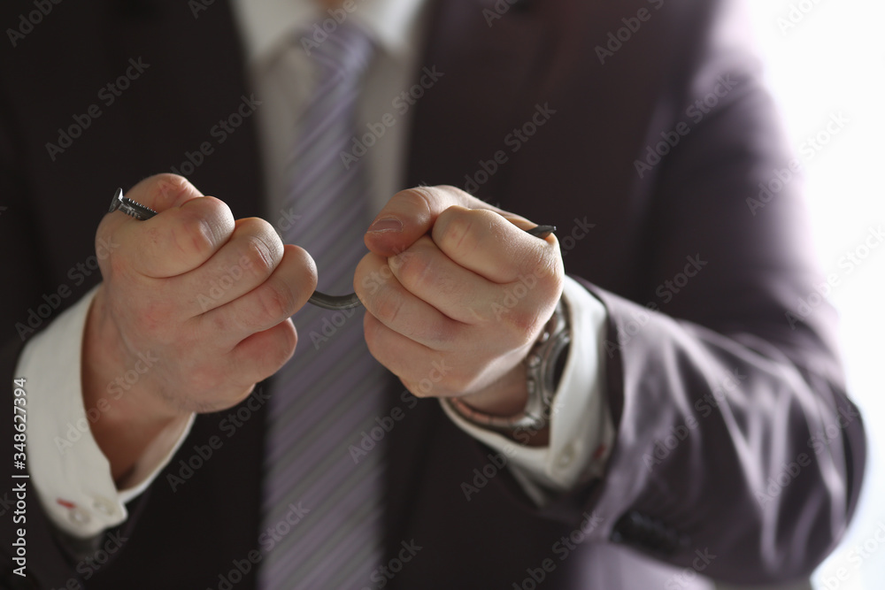 Man in suit and tie bend nail with arms closeup