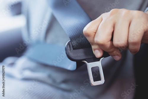 Close Up of people woman hand fastening seat safety belt in car for safety before driving on the road. concept transport travel. soft focus. photo