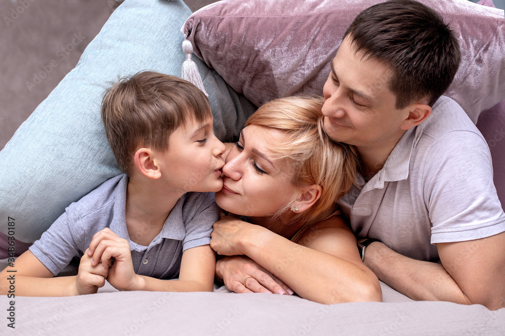 Happy family on a bed with soft pillows at home