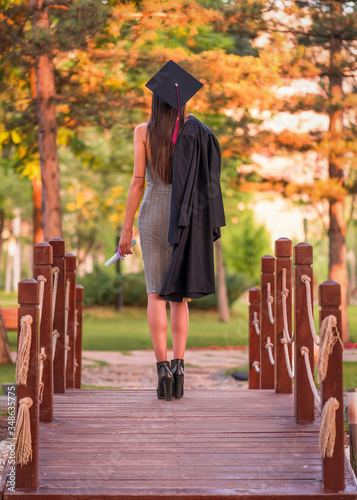 Woman taking a lot of different graduation photos in a beautiful botanical park.