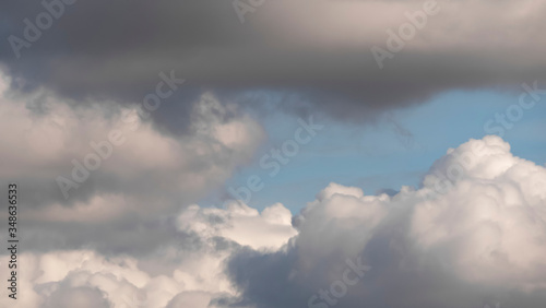 Sky with clouds. Lush  large Cumulus clouds in a clear blue sky illuminated by the rays of the sun on a Sunny day. Realistic sky background. Template. 