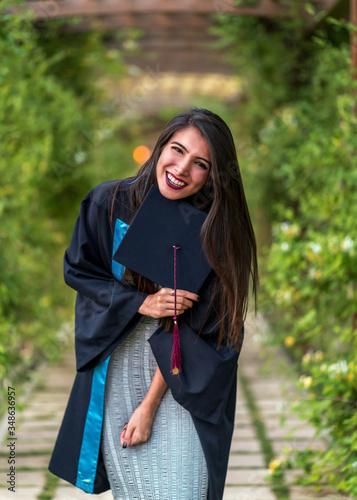 Woman taking a lot of different graduation photos in a beautiful botanical park.
