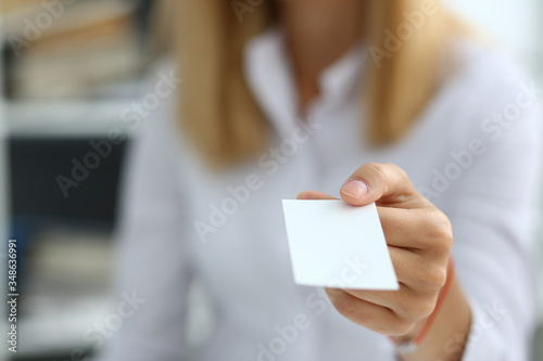 Female hand in suit give blank calling card to male