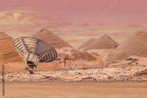A military surveillance radar in a desert between sandy tunes with copy space