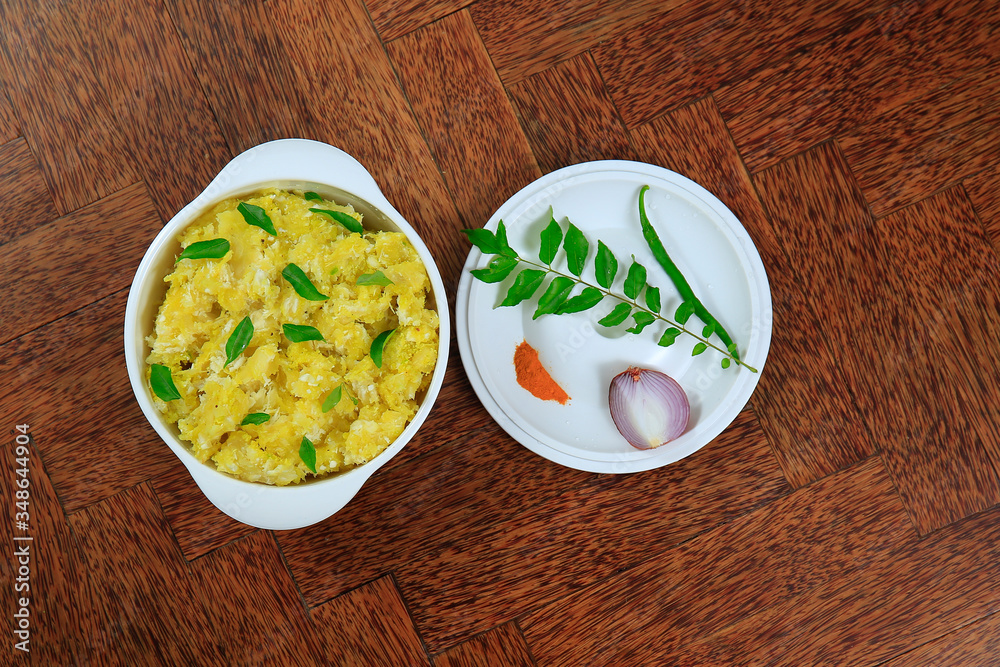 Tasty south indian kappa puzhukku, cooked tapioca in a white bowl isolated on wooden background Tasty south indian kappa puzhukku, cooked tapioca in a white bowl isolated on wooden background