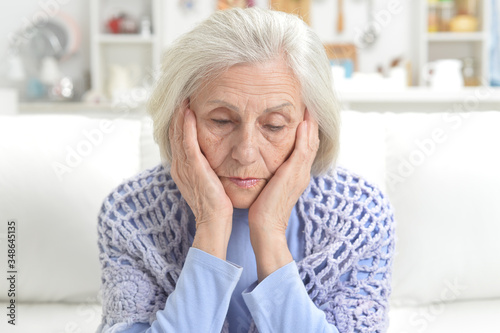 Portrait of sad senior woman with headache