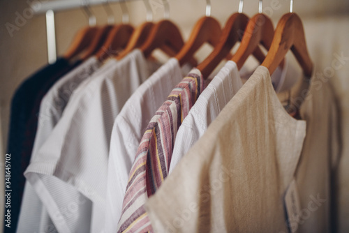 Ready-made dresses of light shades hang on hangers.