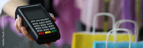 Hand holds out terminal for credit card payment