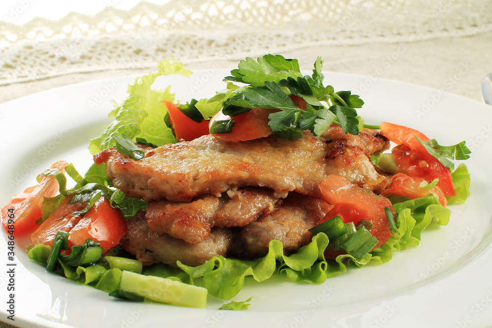 close up of potato with chicken with vegetables and salad on plate