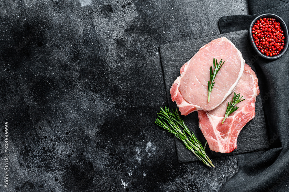 Raw pork chop steak. Organic meat. Black background. Top view. Copy space