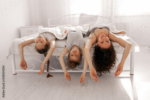 Happy family mother, daughter and son are having fun at home in bedroom. Stay home and homeconcept. photo