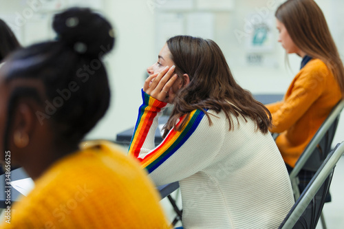 High school girl student taking exam at desk in classroom