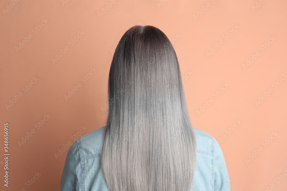 Woman with gray hair on pale pink background, back view Woman with gray hair on pale pink background, back view