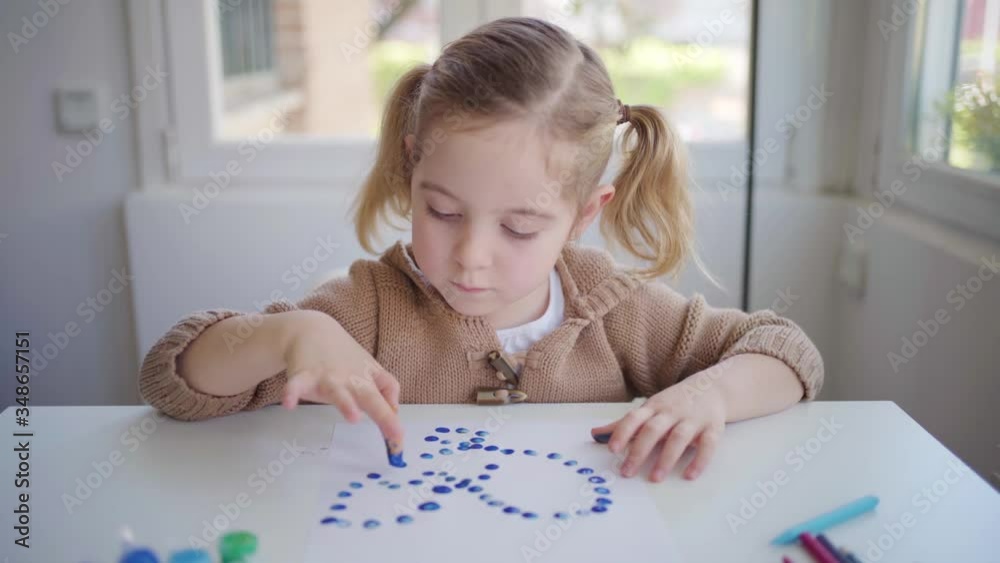 Little girl using gouache for drawing with fingers on paper at home Little girl using gouache for drawing with fingers on paper at home