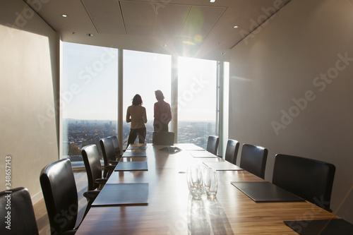 Rear view of business people talking with each other in conference room photo