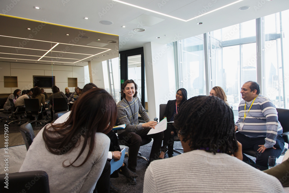 Business people discussing paperwork in circle in meeting Business people discussing paperwork in circle in meeting