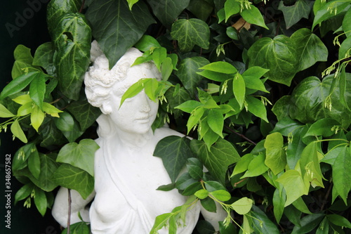 Woman statue covered with leaves 