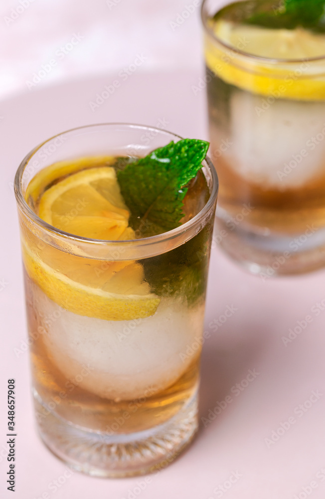 tea with ice, mint and lemon wedges on white table tea with ice, mint and lemon wedges on white table