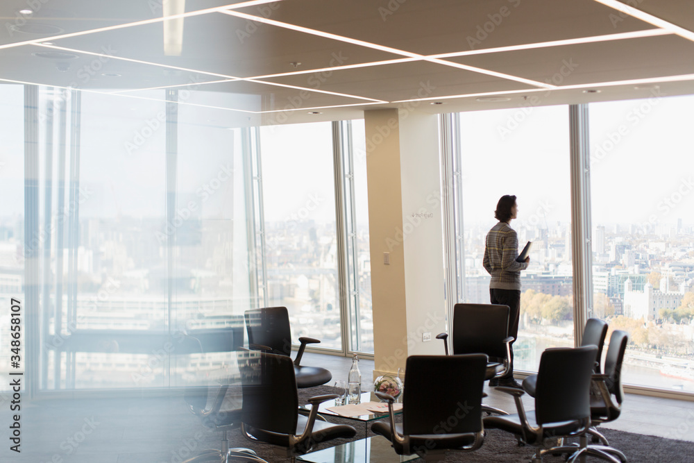 Thoughtful businessman at sunny highrise office window Thoughtful businessman at sunny highrise office window