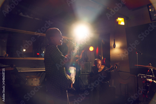 Female musician singing into microphone in recording studio