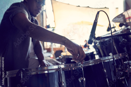 Male drummer adjusting drums in recording studio