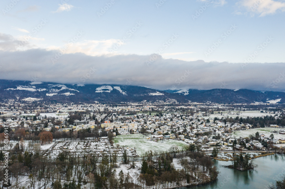 Aerial view of Austrian Alps valley village near Salzburg outskirts in winter during heavy snow time