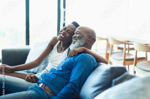 Happy, affectionate father and daughter hugging on living room sofa photo