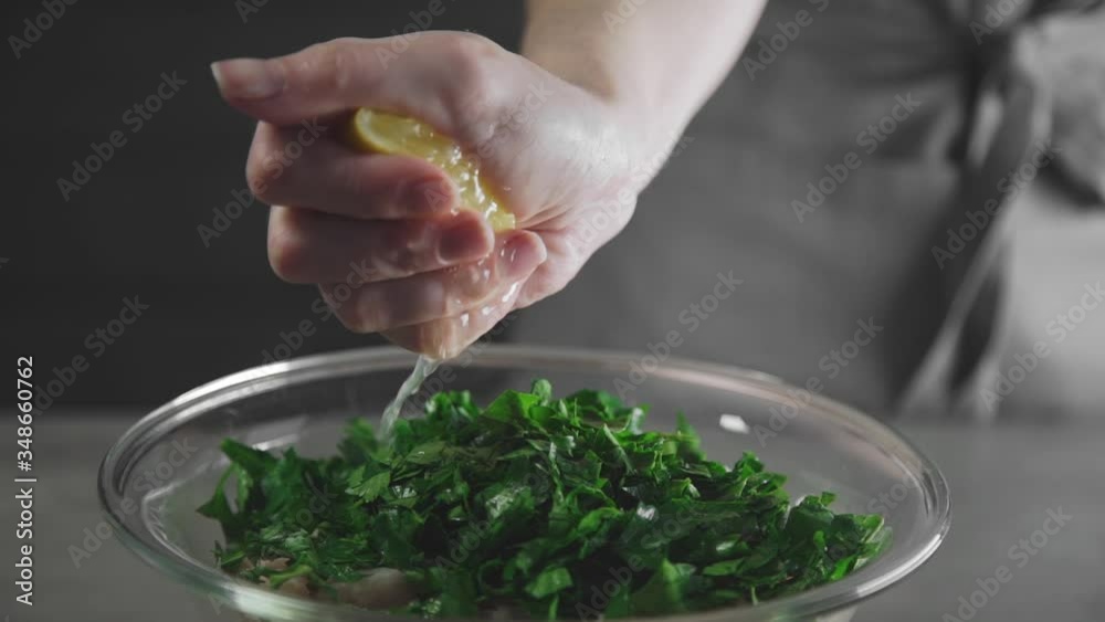 housewife squeezes lemon to the vegetable salad housewife squeezes lemon to the vegetable salad