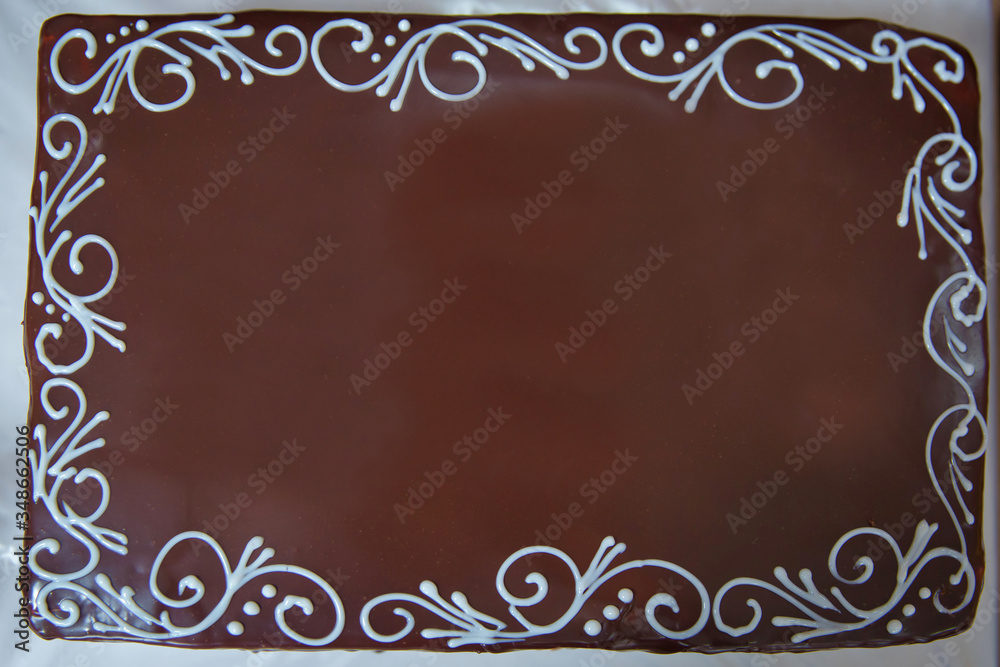 The edges are decorated with white cream . Dark chocolate cake.