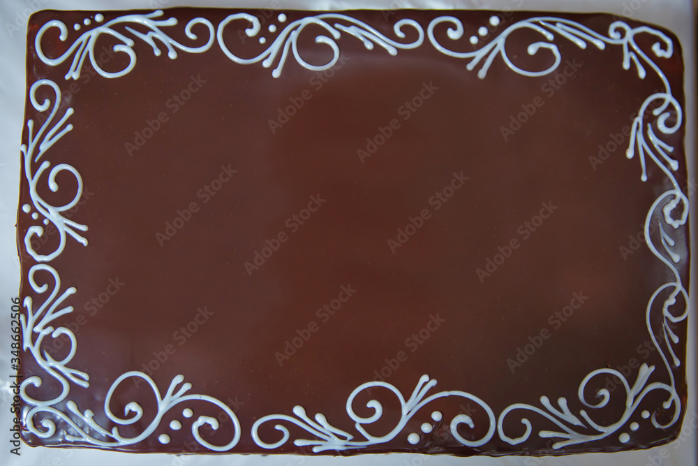 The edges are decorated with white cream . Dark chocolate cake. The edges are decorated with white cream . Dark chocolate cake.