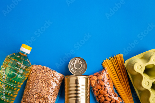 Food donation on blue background, top view. Grocery set. Colorful flat lay with space for text. Food concept.