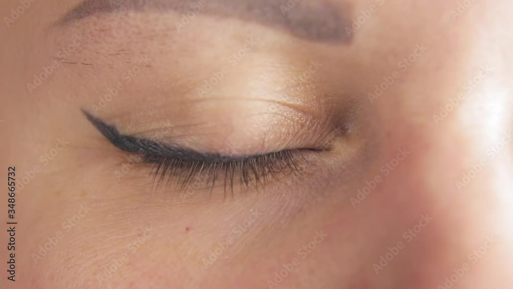 eye of a woman with a green iris with eyeliner and an eyebrow with a slight tattoo eye of a woman with a green iris with eyeliner and an eyebrow with a slight tattoo